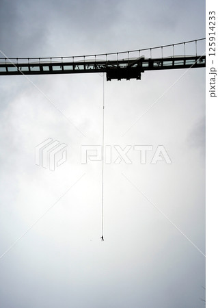 Bungee Jump from a Bridge Under Cloudy Sky 125914233