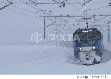 雪の上越線を走る貨物列車 125914512