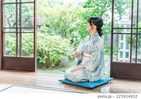 日本家屋の縁側に座る浴衣姿のアジア人女性 125914832
