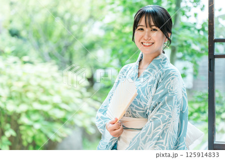 日本家屋の縁側に座る浴衣姿のアジア人女性 125914833