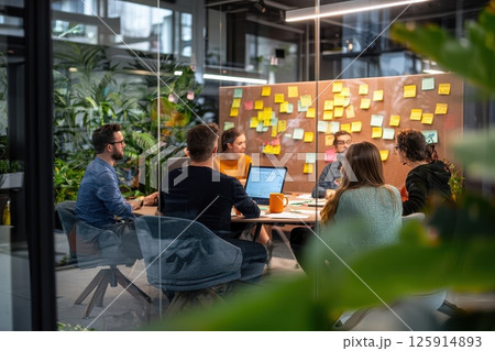 Team Collaboration in Modern Office with Bright Sticky Notes and Plants 125914893