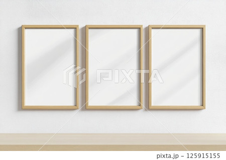 Three wooden framed white pictures are hanging on a wall Three wooden framed white pictures are hanging on a wall 125915155