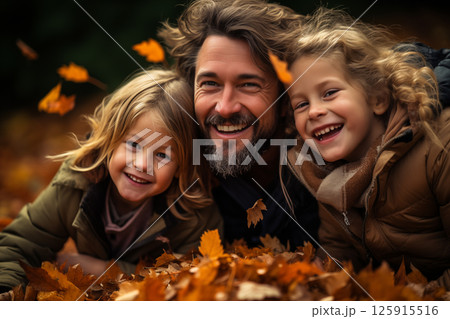 Father and his two children outdoor in autumn leaves. 125915516