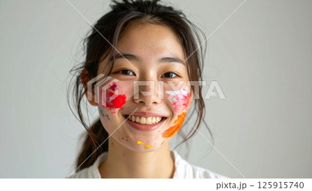 portrait of a smiling young woman with painted face, a cheerful young woman with colorful paint on her face, natural lighting, and bright smile, Perfect for themes of joy, creativity, youth, beauty 125915740