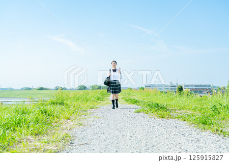 青空の下を歩く女子高校生 125915827