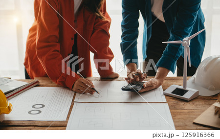 Engineer teams meeting working together wear worker helmets hardhat on construction site in modern city. 125916366