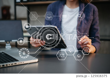 Copyright or patent concept, Person hand using laptop computer, tablet and smartphone with virtual screen copyright icon trademark, Creation ownership against piracy. Copyright or patent concept, Person hand using laptop computer, tablet and smartphone with virtual screen copyright icon trademark, Creation ownership against piracy. 125916375