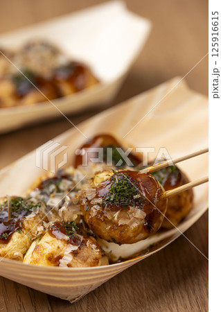 たこ焼きを竹串で刺して持ち上げる様子 125916615
