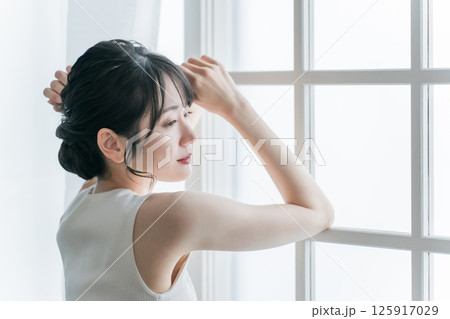 窓際にいる困る・悩む女性(生理痛,体調不良,メンタルヘルス) 窓際にいる困る・悩む女性(生理痛,体調不良,メンタルヘルス) 125917029