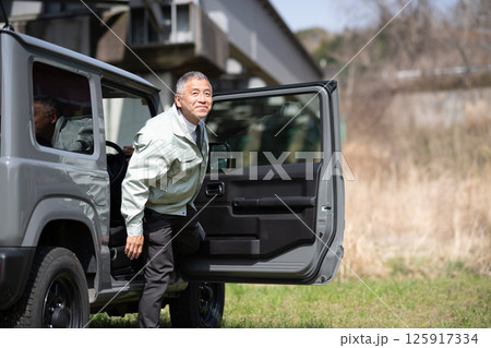 四輪駆動車から降りる職員 125917334