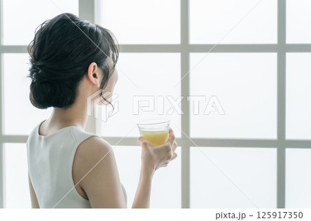 家でグリーンスムージーを飲む若いアジア人女性 家でグリーンスムージーを飲む若いアジア人女性 125917350