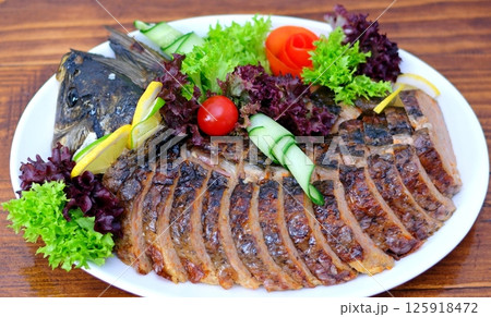 stuffed fish Delicious stuffed carp with lemon and lettuce leaves. stuffed fish Delicious stuffed carp with lemon and lettuce leaves. 125918472