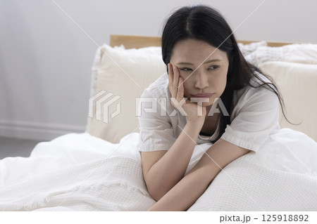 ベッドでぼんやりする女性 125918892