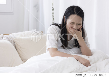ベッドであくびをする女性 125918896
