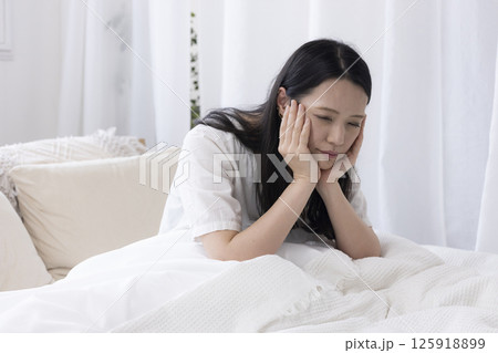 ベッドであくびをする女性 125918899
