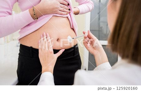 Doctor makes an injection of insulin with a catheter.  Doctor makes an injection of insulin with a catheter.  125920160