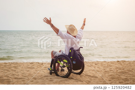 Disabled man in a wheelchair on the beach. 125920482