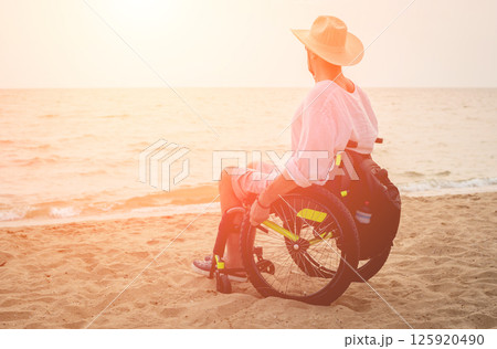 Disabled man in a wheelchair on the beach. Disabled man in a wheelchair on the beach. 125920490
