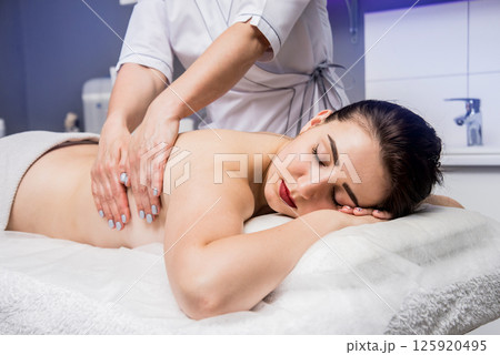 Beautiful young woman enjoying massage in spa salon. Cosmetology Beautiful young woman enjoying massage in spa salon. Cosmetology 125920495