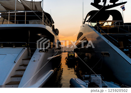 View of harbor with yachts details. Beautiful sunset sky in the marina bay. 125920502