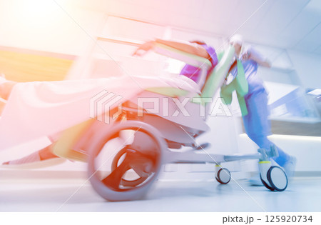 Nurse moves mobile medical chair with patient at hospital. Medical equipment. 125920734