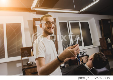 Young man with trendy haircut at barber shop.  125920749