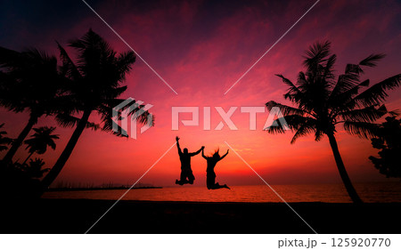 Silhouette of couple on tropical beach during sunset on background of palms Silhouette of couple on tropical beach during sunset on background of palms 125920770