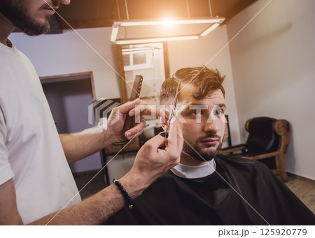 Young man with trendy haircut at barber shop. Young man with trendy haircut at barber shop. 125920779