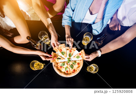 Cheerful friends in the pub. Drinking beer, eating pizza, talking, having fun. Cheerful friends in the pub. Drinking beer, eating pizza, talking, having fun. 125920808