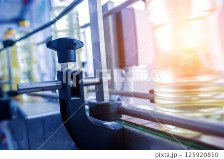 Bottling line of sunflower oil in bottles. Vegetable oil production plant Bottling line of sunflower oil in bottles. Vegetable oil production plant 125920810