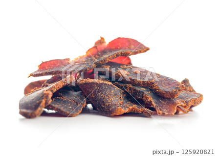 Beef jerky. Dried spiced meat isolated on white background. 125920821