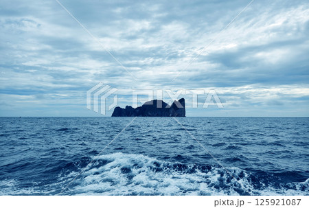 There is a small secluded island located in the middle of the ocean There is a small secluded island located in the middle of the ocean 125921087