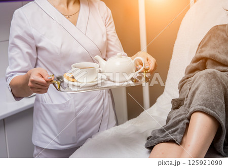 Young woman drinking herbal tea after spa procedures. 125921090