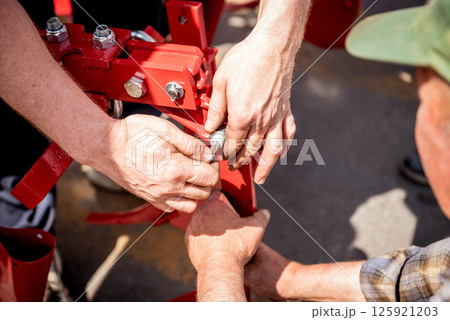 The mechanics repair combine harvester. Modern agricultural machinery The mechanics repair combine harvester. Modern agricultural machinery 125921203
