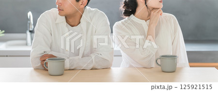 ダイニングに座る冷めた表情の若い夫婦・カップル(夫婦関係・倦怠期・マンネリ・仮面夫婦・夫婦喧嘩) ダイニングに座る冷めた表情の若い夫婦・カップル(夫婦関係・倦怠期・マンネリ・仮面夫婦・夫婦喧嘩) 125921515