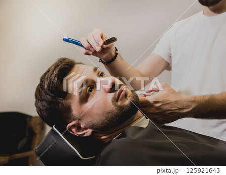 Young man with trendy haircut at barber shop. Young man with trendy haircut at barber shop. 125921643