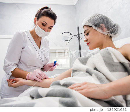 The doctor cosmetologist makes cosmetology dropper procedure. Infusion. 125921681