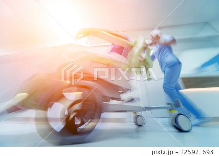 Nurse moves mobile medical chair with patient at hospital. Medical equipment. 125921693