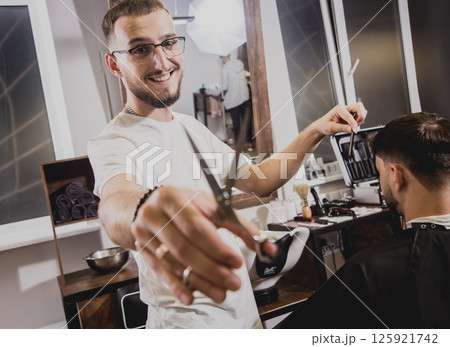 Young man with trendy haircut at barber shop.  125921742