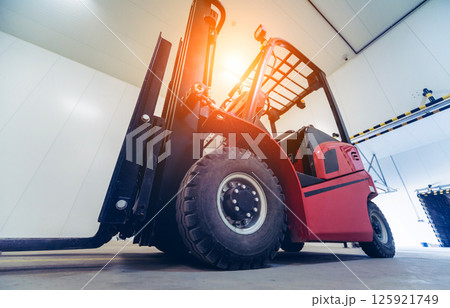 Forklift in a large industrial freezer warehouse.  125921749