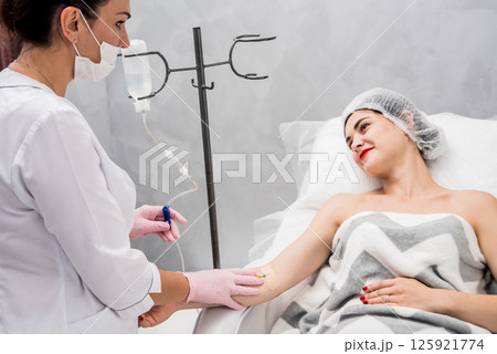 The doctor cosmetologist makes cosmetology dropper procedure. Infusion. The doctor cosmetologist makes cosmetology dropper procedure. Infusion. 125921774