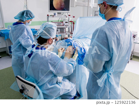 Arthroscope surgery. Orthopedic surgeons in teamwork in the operating room Arthroscope surgery. Orthopedic surgeons in teamwork in the operating room 125922136