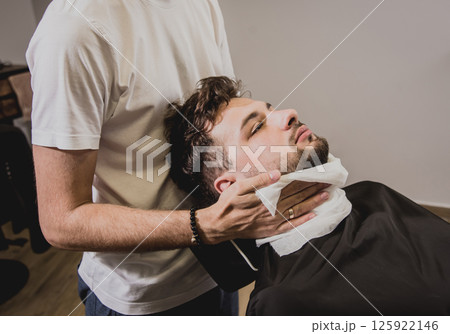 Young man with trendy haircut at barber shop.  125922146