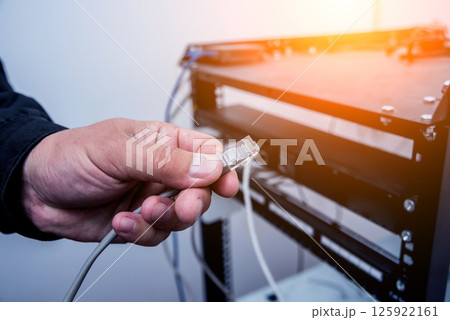Technician connecting network cables to switches. Connecting cables  125922161