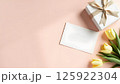 Elegant Gift Composition with Tulips and Blank Card on Pastel Background 125922304