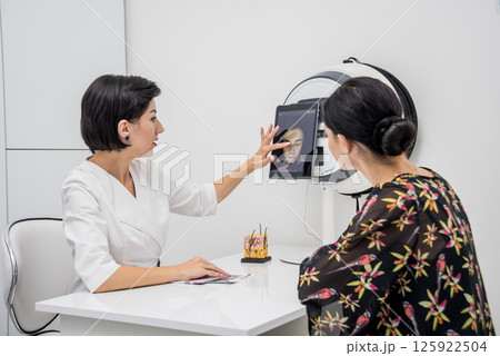 Face skin analyze system. Cosmetologist analyzing woman face.  125922504