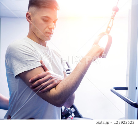 Rehabilitation therapy. Young man doing exercises on mat  125922522