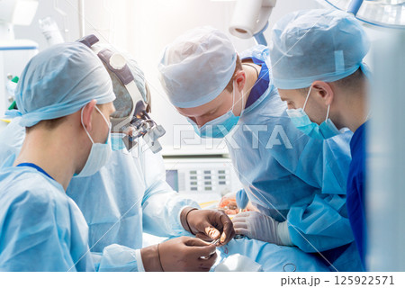 Spinal surgery. Group of surgeons in operating room with surgery equipment. 125922571