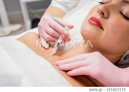 The doctor cosmetologist makes the neckline injections procedure. The doctor cosmetologist makes the neckline injections procedure. 125922572