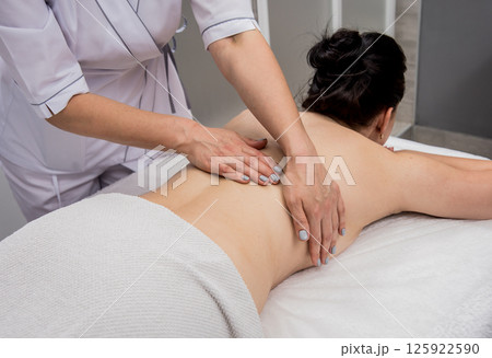 Beautiful young woman enjoying massage in spa salon. Cosmetology Beautiful young woman enjoying massage in spa salon. Cosmetology 125922590